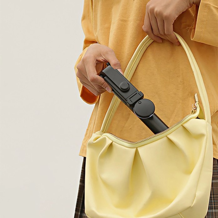 Kobieta pozująca z selfie stickiem WH1YXS